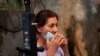 Una mujer israelí baja su mascarilla para fumar un cigarrillo en un mercado del pueblo de Rambla, cerca de Tel Aviv, el pasado 15 de julio.