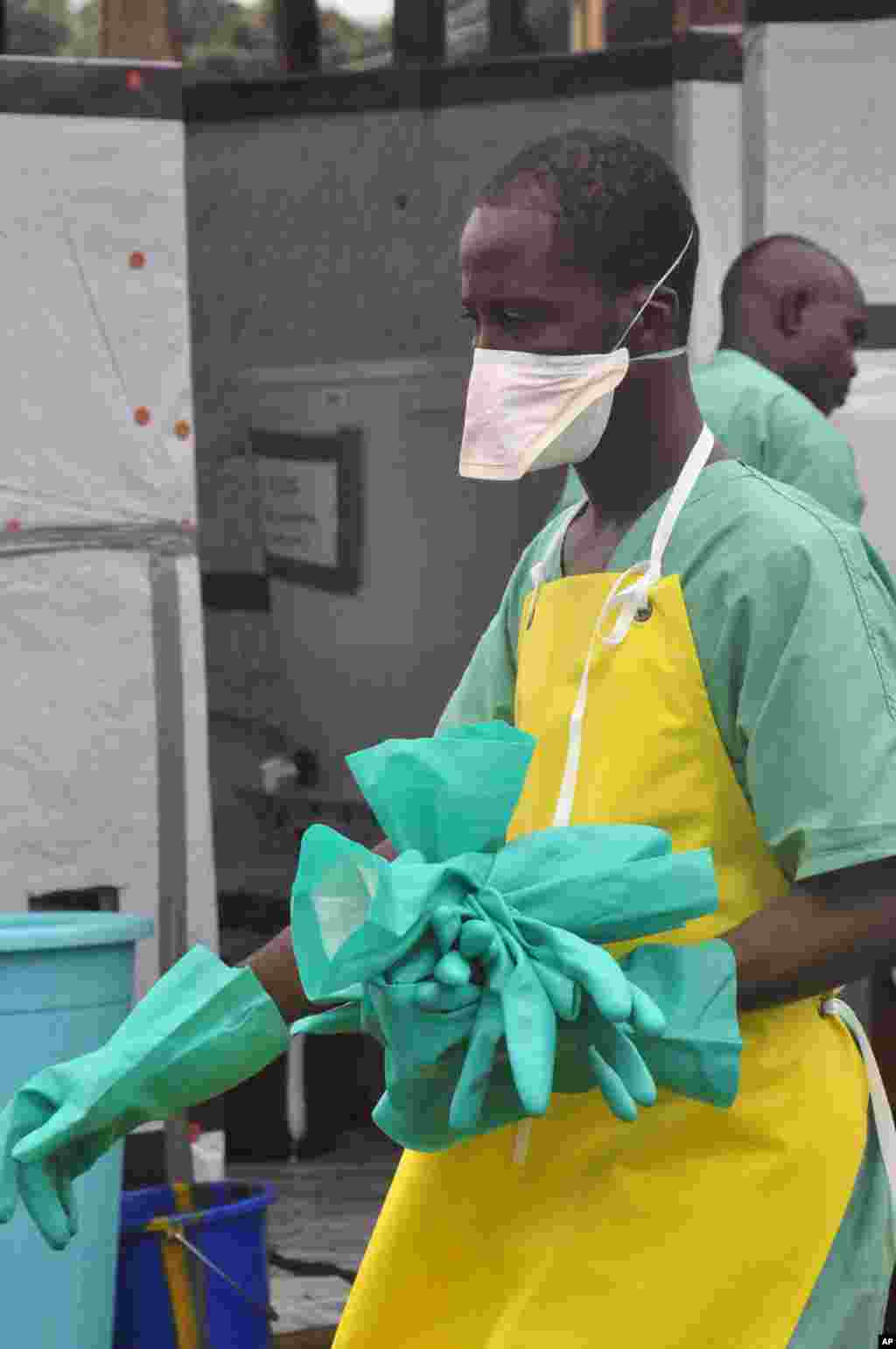A health worker carries gloves at an Ebola treatment center, Monrovia, Liberia, Aug. 18, 2014. 