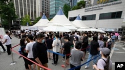 9일 한국 서울에서 신종 코로나바이러스 감염 검사를 받기 위해 줄 선 사람들.