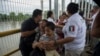 Une mère migrante du Honduras et son fils traversent le pont après avoir franchi la frontière entre le Guatemala et le Mexique, à Ciudad Hidalgo, au Mexique, le samedi 20 octobre 2018. 