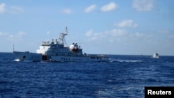 FILE - Chinese ships chase Vietnamese ships, not shown, after they came within 10 nautical miles of a Chinese oil rig in the South China Sea, July 15, 2014. 