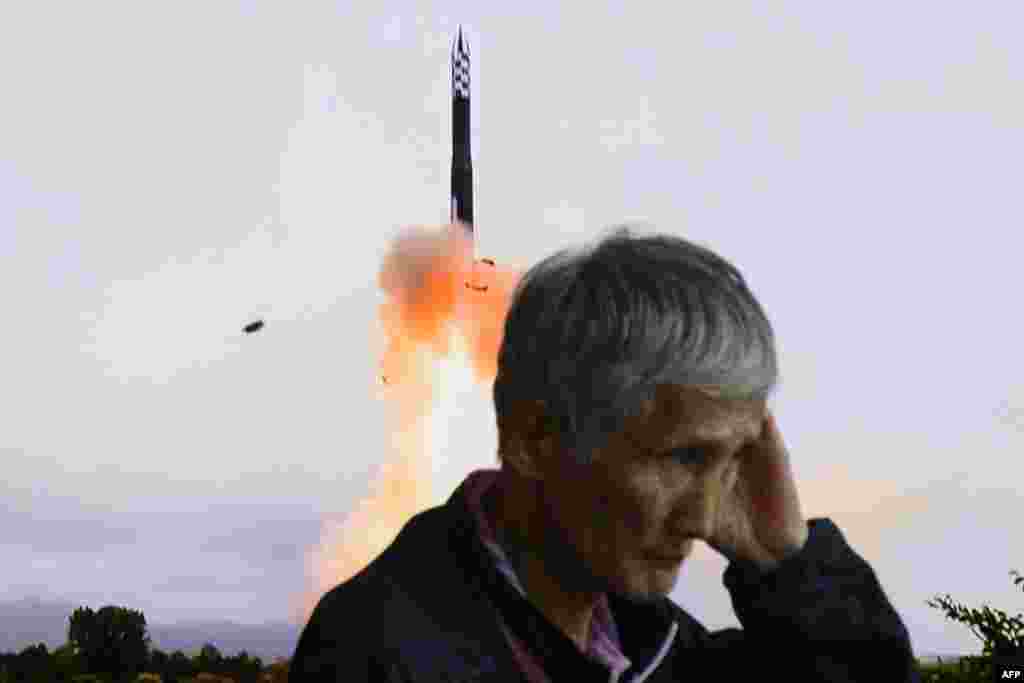 A man walks past a television screen showing a news broadcast with file footage of a North Korean missile test, at a train station in Seoul. North Korea fired a salvo of short-range ballistic missiles early on September 18, Seoul's military said, Pyongyang's second such weapons test in a week. 