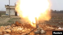 FILE - Free Syrian Army fighter fires a shell towards Islamic State fighters in the northern Aleppo countryside, Syria.