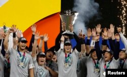 FILE - Shohei Ohtani (C) and team Japan celebrate with the World Baseball Classic trophy after defeating the U.S. in the World Baseball Classic at LoanDepot Park on March 21, 2023. (Rhona Wise-USA TODAY Sports)