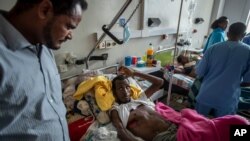 FILE - In this May 6, 2021, file photo, a recovering farmer, who says he was shot by Eritrean forces, speaks to a doctor at a hospital in Mekele. The U.S. has imposed sanctions on Eritrea's chief of staff of the defense forces, Filipos Woldeyohannes.