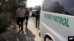 Petugas Patroli Perbatasan AS menahan imigran yang diduga menyeberang ke Amerika secara ilegal melalui Rio Grande dekat Granjeno, Texas, 11 Agustus 2017.