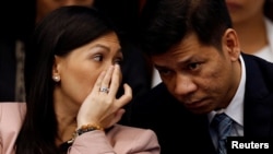 FILE - Maia Santos Deguito, a branch manager of the Rizal Commercial Banking Corp (RCBC), whispers to her lawyer as she testifies during a Senate hearing on money laundering involving $81 million stolen from Bangladesh central bank, at the Philippine Senate in Manila, April 12, 2016. 