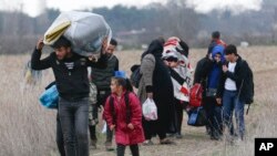 Migrants walk near Pazarkule at the Turkish-Greek border on Thursday, March 5, 2020.