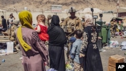 Anggota Korps Marinir AS Unit Ekspedisi Marinir ke-24 memproses pengungsi saat mereka melewati pusat kendali evakuasi di Bandara Internasional Hamid Karzai di Kabul, Afghanistan, 28 Agustus 2021.