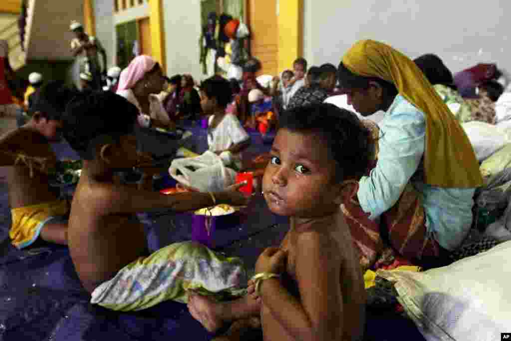 Seorang anak dari etnis Rohingya makan di dalam tempat penampungan setelah diselamatkan, bersama dengan ratusan lainnya dari kapal, di Lhoksukon, Aceh (12/5). (Reuters/Roni Bintang)