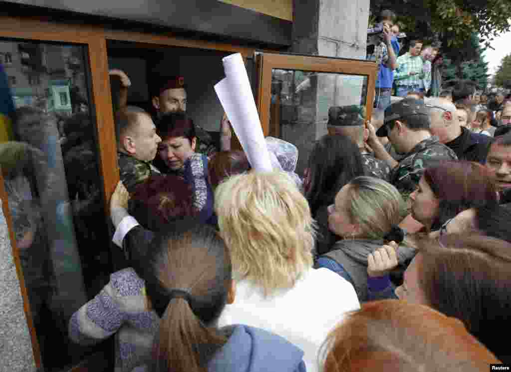 Public activists and relatives of soldiers who say the soldiers are surrounded by pro-Russian separatists in eastern Ukraine, try to get into the defense ministry building during a protest, in Kyiv, Aug. 28, 2014. 