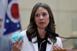 FILE - In this Feb. 27, 2020, photo Ohio Department of Health Director Dr. Amy Acton holds up a mask as she gives an update on the state's COVID-19 preparedness and education efforts.