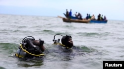 Members of the Uganda Police Marine Unit participate in rescue efforts after a boat carrying mostly Congolese refugees capsized in Lake Albert southwest of Uganda's capital, Kampala, March 23, 2014.