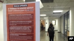A student walks past a tip sheet for Deferred Action for Childhood Arrivals recipients who fear deportation that is taped to a window on the University of California, Berkeley campus in Berkeley, California, Sept. 7, 2017. Colleges and universities nationwide are stepping up efforts to help the students who are often called "Dreamers," after the Trump administration announced plans last week to end that federal program protecting immigrants brought to the U.S. illegally as children.