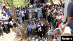 Familiares de víctimas de la violencia en Irak rezan durante un funeral en Kirkuk el 23 de junio.