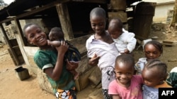 FILE - Young Cameroonian refugees carry children in Agborkim town, Etung district of Cross Rivers State, southeast Nigeria, Feb. 2, 2018. Millions of Cameroonian children reportedly do not have required birth certificates. 