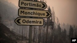 Un poste con señales se mantiene de pie en medio de terreno calcinado en el pueblo de Monchique, en la región de Algarve, en el sur de Portugal, el 6 de agosto de 2018. Servicios de emergencia dicen que continúan combatiendo un masivo incendio forestal en la costa sur del país que amenazaba una comunidad el domingo por la noche. Foto: AP/Javier Fergo.