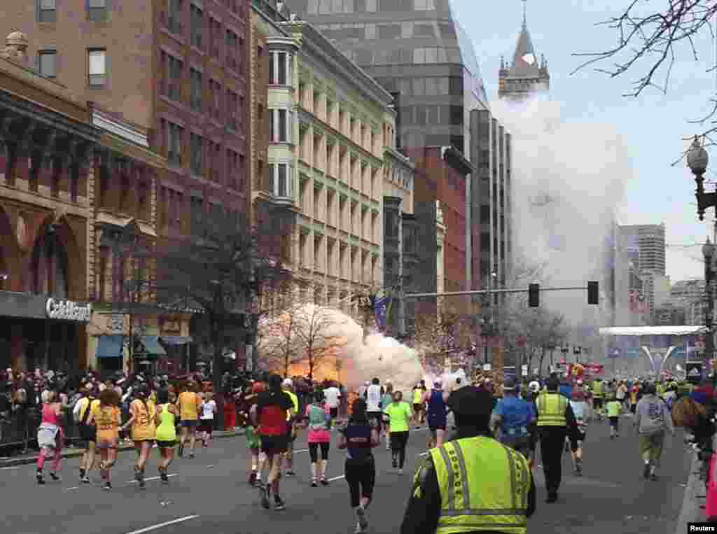 Para peserta Marathon Boston terus berlari menuju garis finish menyusul ledakan bom dekat garis itu di Boston, Massachusetts (15/4). (Reuters/Dan Lampariello)