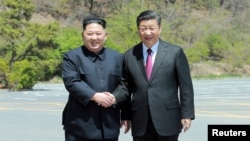 中國國家主席習近平 (右) 在大連與到訪的北韓領導人金正恩握手。 （2018年5月9日）
