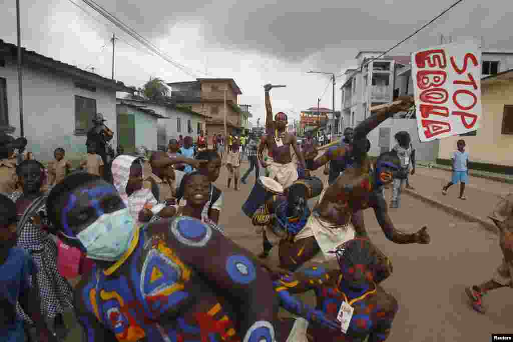 Actors parade on a street after performing at Anono school, during an awareness campaign against Ebola, in Abidjan, Ivory Coast, Sept. 25, 2014.
