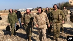 FILE - General Frank McKenzie, center front, the top U.S. commander for the Middle East, walks as he visits a military outpost in Syria, Jan. 25, 2020. 
