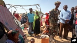 A Somali soldier provides security as newly displaced Somalis gather at a camp on the outskirts of Mogadishu, Somalia, March 28, 2017. A new report says cross-border airstrikes by Kenya have been targeting civilians in pastoral communities in Somalia's Gedo region.