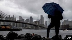 ARCHIVO - Un hombre se para cerca del East River y el puente de Brooklyn, en Nueva York. (AP/Julia Nikhinson)