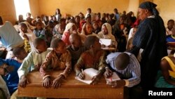 Children listen to a school teacher after the reopening of Mahamane Fondogoumo elementary school in the town center of Timbuktu, Mali, February 1, 2013.