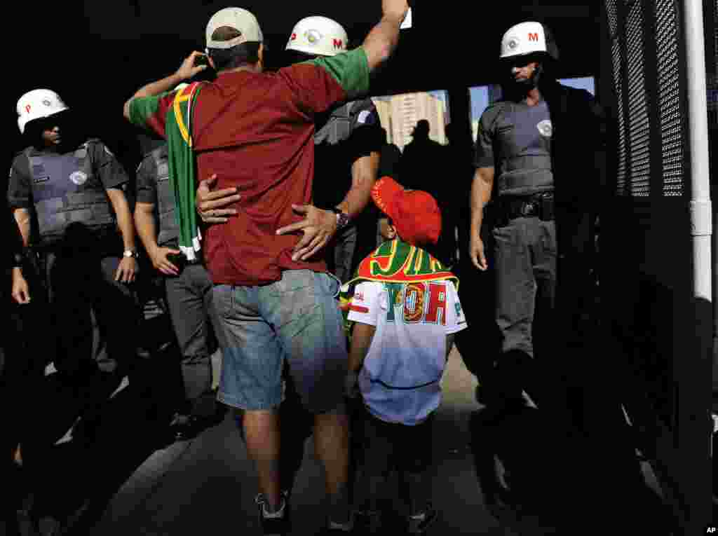 Brazilian police check soccer fans before they go into the stadium to watch Portugal's training session in Campinas, Brazil, June 18, 2014.