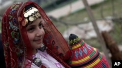 FILE - A Yemeni girl in traditional costume poses for a picture during the opening ceremony of Sanaa Summer Festival in Sanaa, Yemen, Aug. 18, 2013. 