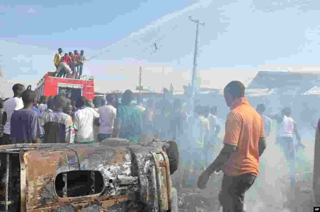 People gather at the scene of a car bomb explosion at the central market, Maiduguri, Nigeria, July 1, 2014.