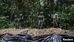 Soldados del ejército colombiano patrullan una piscina improvisada de crudo robado de un oleoducto cercano por grupos ilegales para la producción de un combustible artesanal llamado "Pategrillo", en Tumaco, Colombia, el 8 de septiembre de 2022.