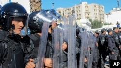 FILE - Riot Police face demonstrators during a rally against Tunisian President Kais Saied in Tunis, Tunisia, Nov. 14, 2021. A Tunisian corruption fighter will stand trial again in a military court Monday, Nov. 22. He is accused of insulting the presidency and defaming the army. 