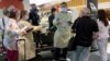 Penumpang yang datang diperiksa petugas kesehatan di bandara Sydney, Australia, 12 Februari 2021. (Foto: AP)