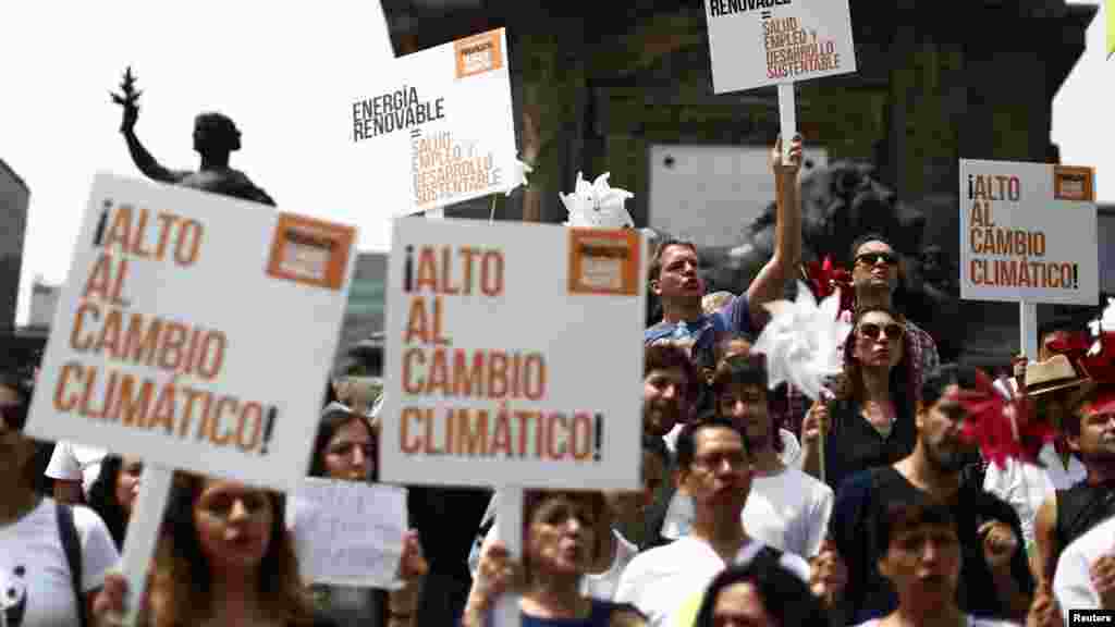 Para demonstran di Mexico City (21/9) memegang spanduk dan menari dalam Pawai Perubahan Iklim yang menuntut politisi mengambil tindakan lebih keras untuk melindungi iklim.(Reuters/Edgard Garrido)
