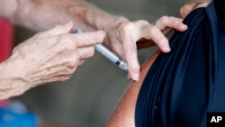 A man receives a COVID-19 vaccine at a clinic at Mother's Brewing Company in Springfield, Mo., on Tuesday, June 22, 2021.(Nathan Papes/The Springfield News-Leader via AP)