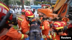 Rescue workers move a casualty at the site of a hotel being used for the coronavirus quarantine collapsed, in the southeast Chinese port city of Quanzhou, Fujian province, China, March 8, 2020.