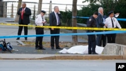 警方在出事現場調查。一名死者遺體被蒙上白布