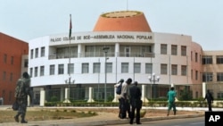 A picture taken on March 19, 2012 shows residents walking by the Parliament in Bissau.