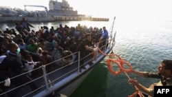 Ilegalni migranti različitih afričkih nacionalnosti dolaze u pomorsku bazu u Tripoliju.