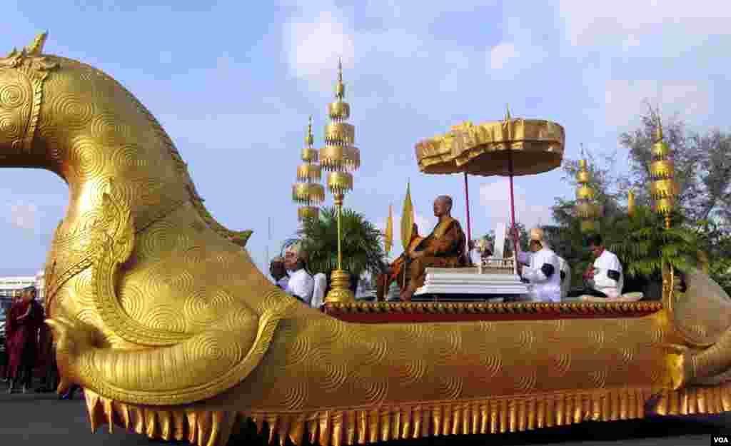 Bou Kry, one of Cambodia's two Buddhist patriarchs, sits in a royal truck leading the procession that carries the coffin and body of late former King Norodom Sihanouk from the airport to the Royal Palace.(Heng Reaksmey/VOA)