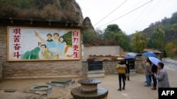 2016年10月22日，在中國陝西省梁家河，中國國家主席習近平青年時期生活過的窯洞外面有一幅描繪青年習近平指引方向的壁畫。