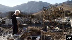 Marsha Maus, who has lived in the Seminole Springs Mobile Home Park for 15 years, looks through her charred belongings, NSunday,
