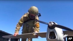 На цьому відеокадрі з відео пресслужби Міноборони Росії 8 серпня 2022 року, видно, як російський військовослужбовець готує до запуску розвідувальний безпілотник "Орлан-10". (Фото пресслужби Міноборони РФ через AP)