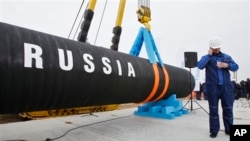 FILE - A Russian construction worker speaks on a mobile phone in Portovaya Bay some 170 kms (106 miles) northwest from St. Petersburg, Russia, during a ceremony marking the start of Nord Stream pipeline construction, April 9, 2010.
