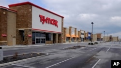 An empty parking lot is seen at closed retail stores April 15, 2020, in Whitestown, Ind. Sales at retail stores have plunged. 