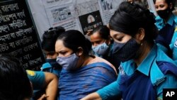 Bangladeshi journalist Rozina Islam, center, is escorted by police to a court in Dhaka, Bangladesh, May 18, 2021.