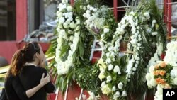 Family members of a victim of the Casino Royale's deadly arson attack stand at a makeshift memorial, in front of the charred gambling house in Monterrey, Mexico, August 27, 2011