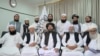 Mullah Baradar Akhund, seorang pejabat senior Taliban, duduk bersama sekelompok pria, membuat pernyataan video, dirilis pada 16 Agustus 2021. (Foto: Media Sosial via REUTERS)
