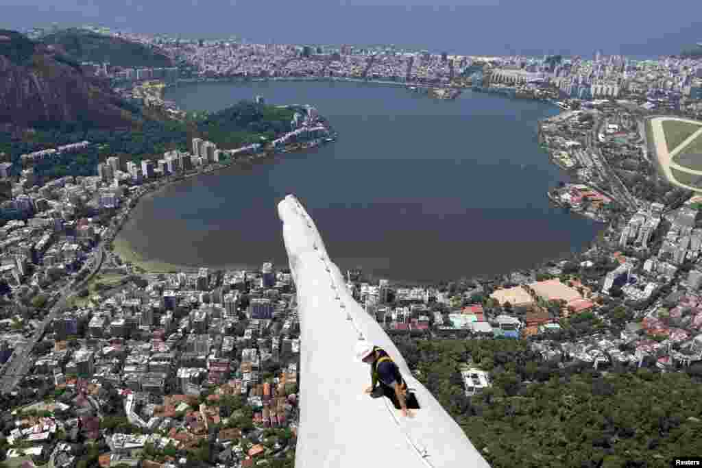 Seorang pekerja memeriksa patung Yesus yang rusak akibat sambaran halilintar di kota Rio de Janeiro, Brazil. Halilintar merusak bagian kepala dan tangan kanan patung Yesus.